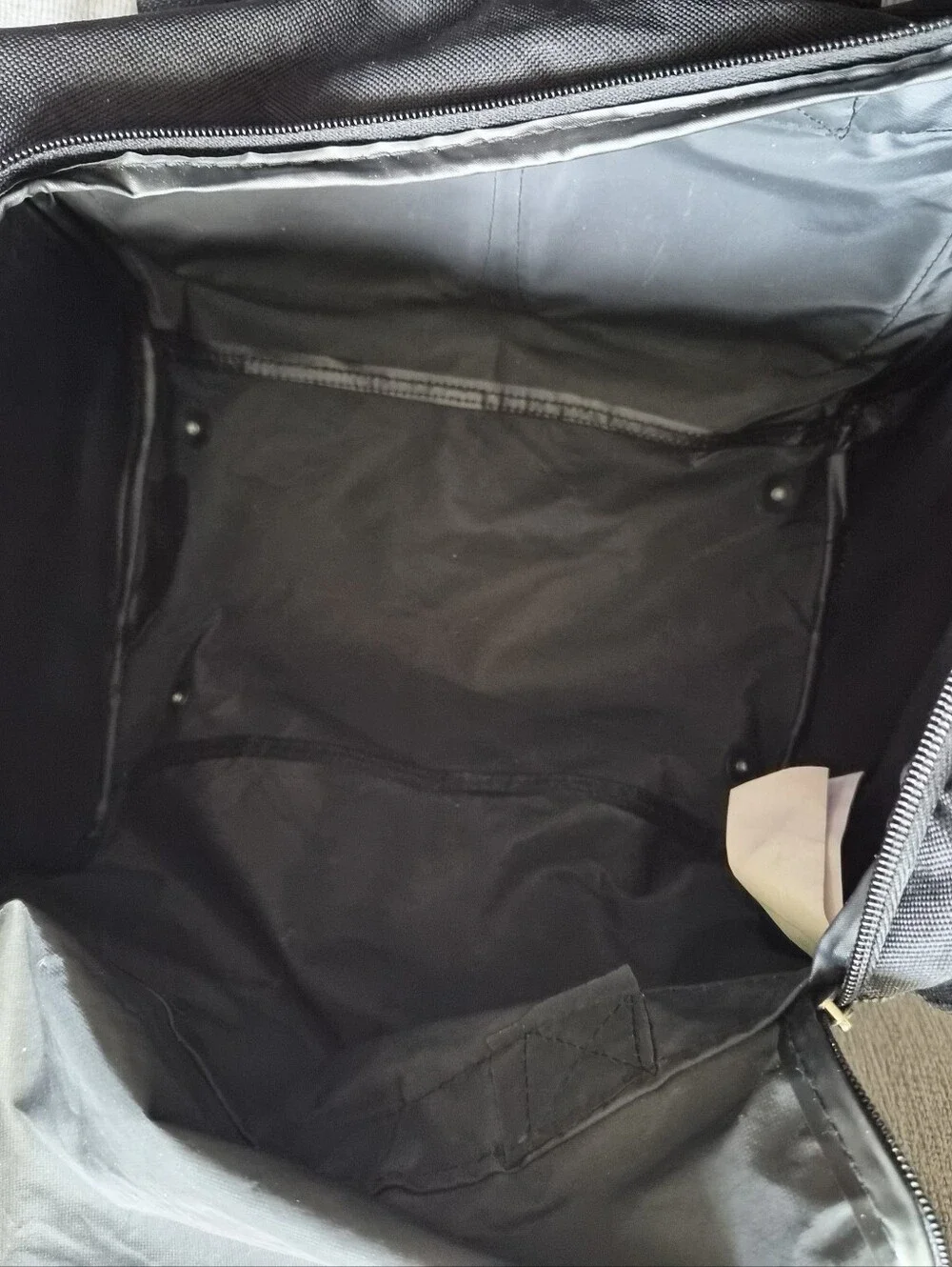 This black Tournamax duffel bag features a prominent logo and secured  pockets